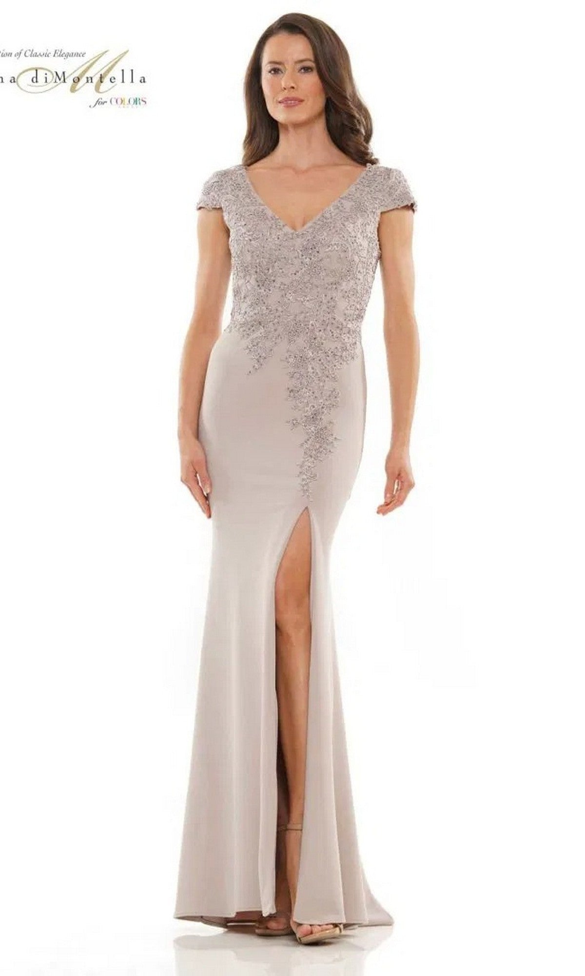 A woman wearing the Rina Di Montella RD2763 long formal dress in taupe, featuring short sleeves, a sheath skirt, floral embellishments, an embroidered bodice, and a high side slit.